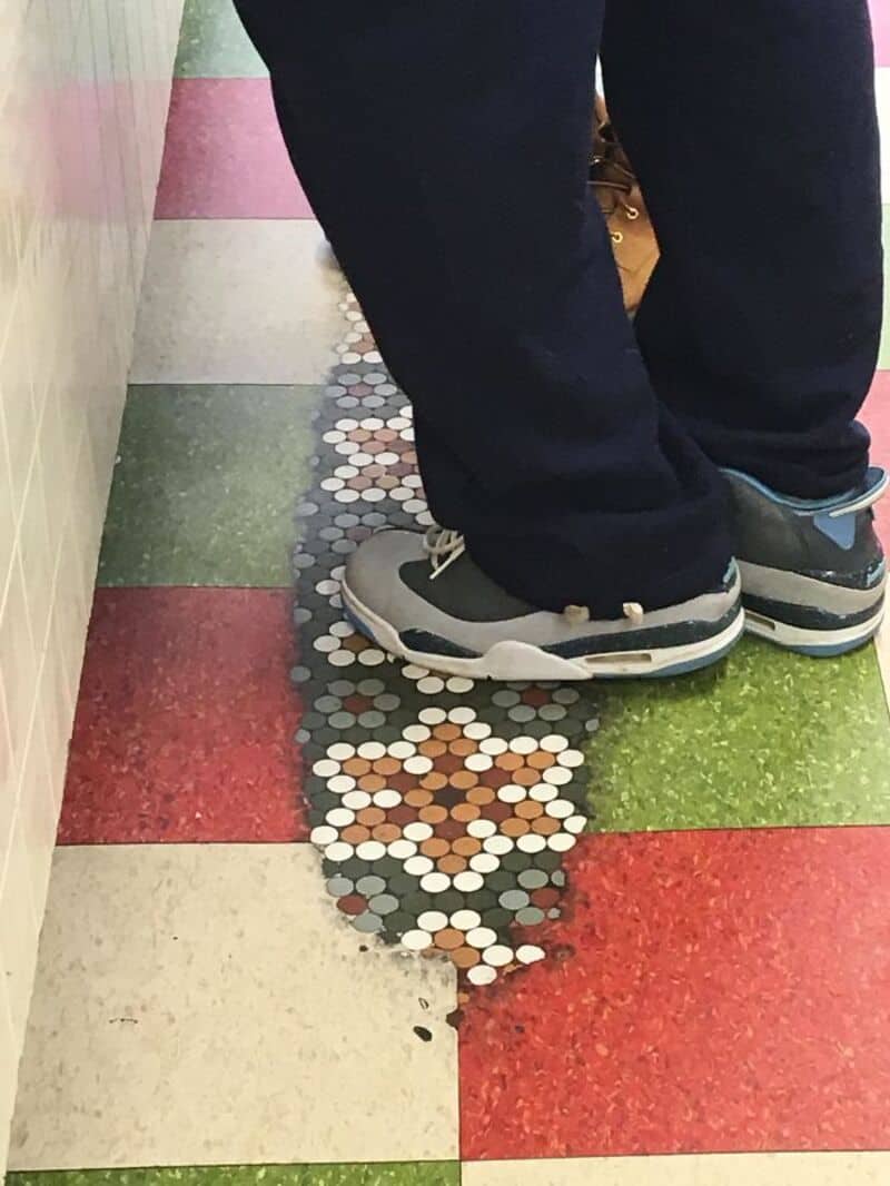 Person standing on colorful tiled floor with a floral mosaic pattern.