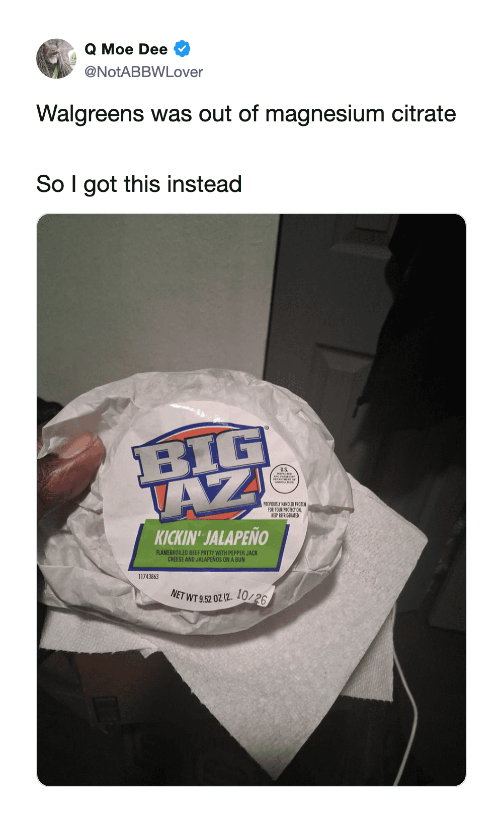 Big AZ snack with jalapeño flavor, held in hand, on a white surface.