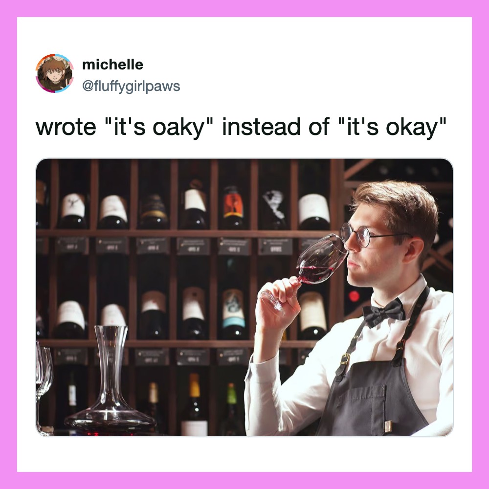 Man in apron smelling wine at a wine tasting, shelves of bottles in background.