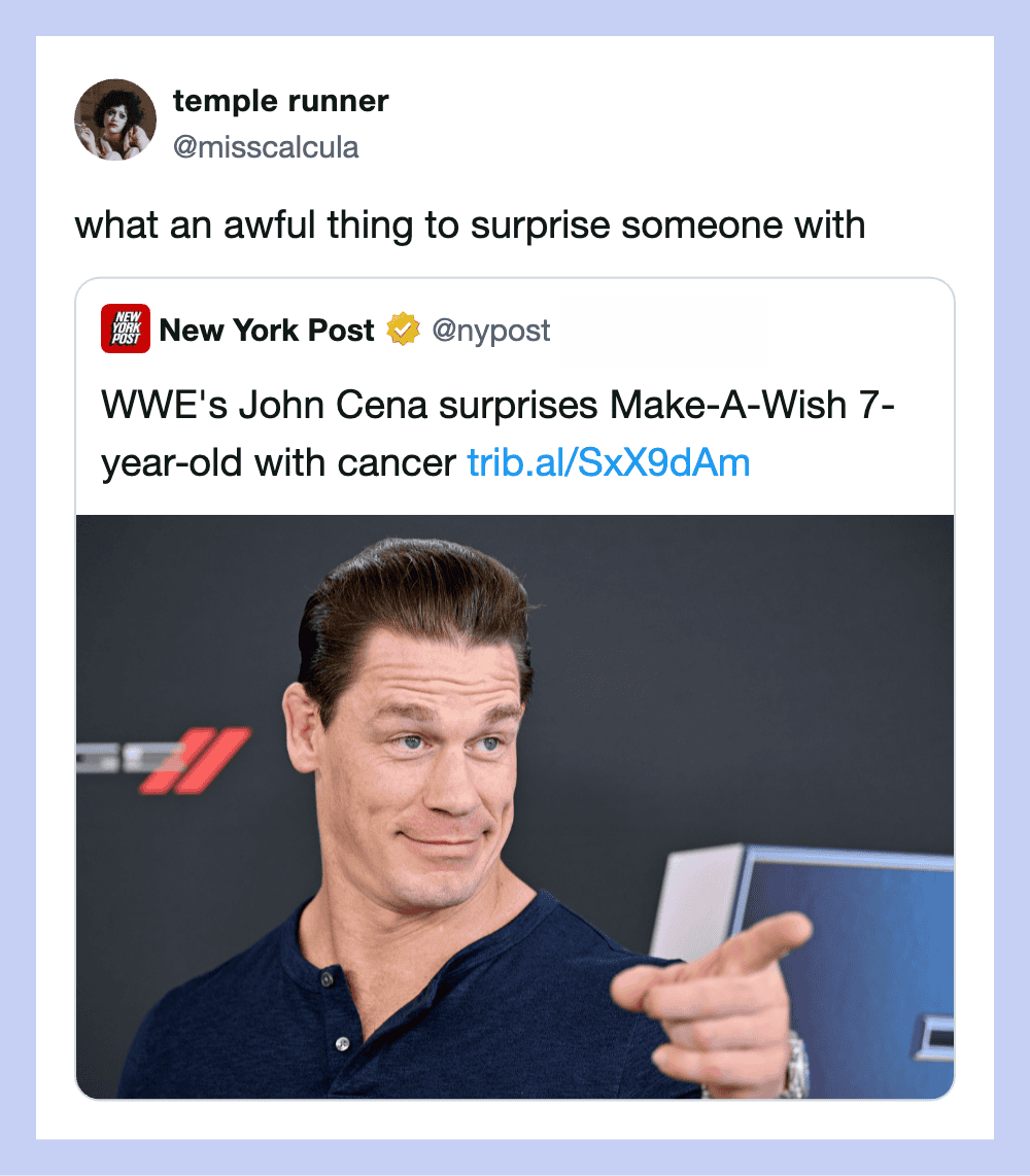 John Cena points with a smirk in front of a dark background.