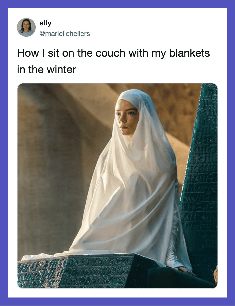Woman sitting on a couch with a blanket in winter, wearing a white blanket like a cloak.