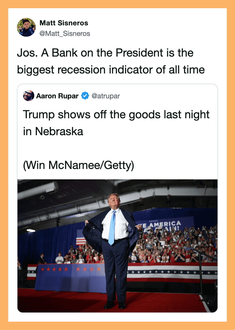 Trump on stage at a rally with a crowd and a banner that says 'America First'.