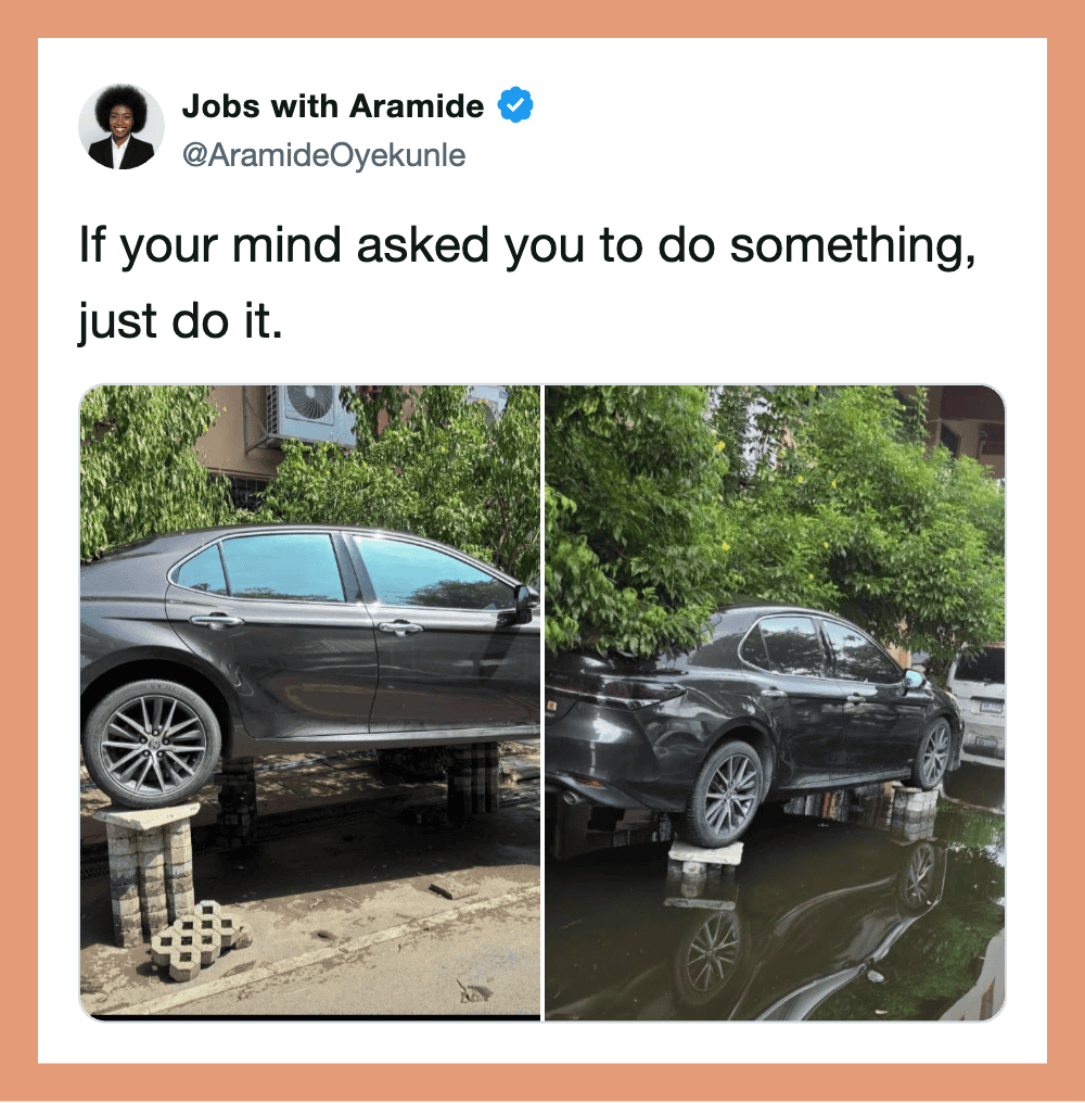 Two cars are parked on makeshift supports, one on bricks and the other on blocks, with water beneath.