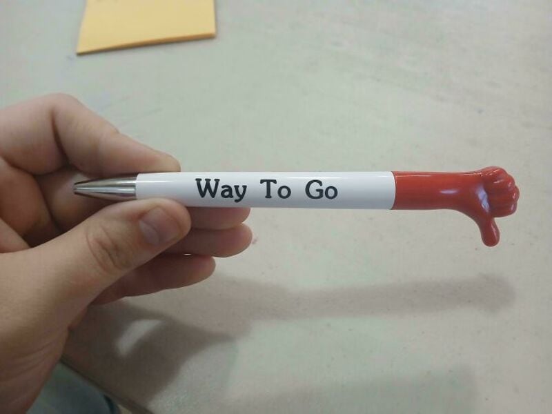 Pen with a red plastic hand at the end and 'Way To Go' written on it.