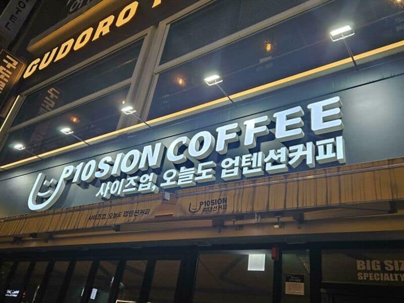 Fusion of coffee shop sign with Korean text and a smiley face logo.