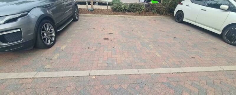 Parking lot with a poorly painted line dividing spaces, making it confusing.