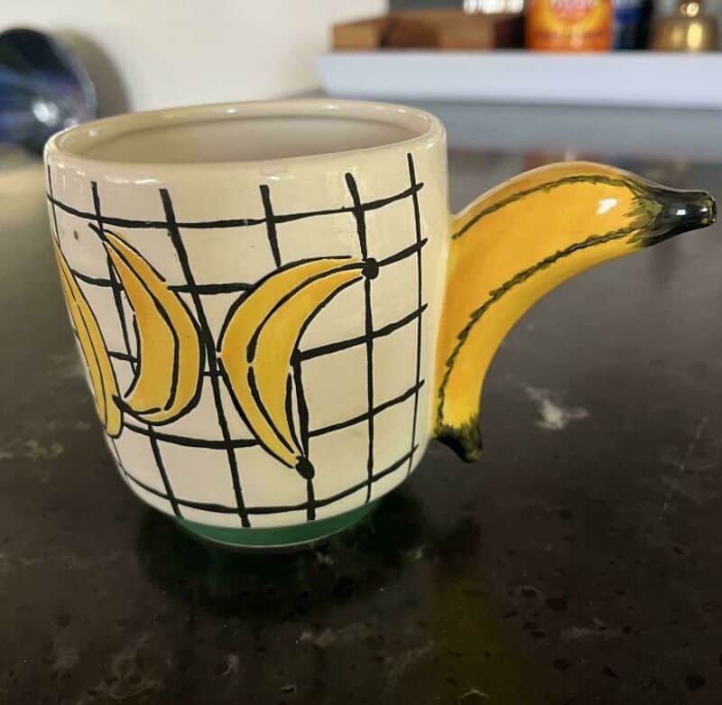 Mug with banana and grid design, handle shaped like a banana.