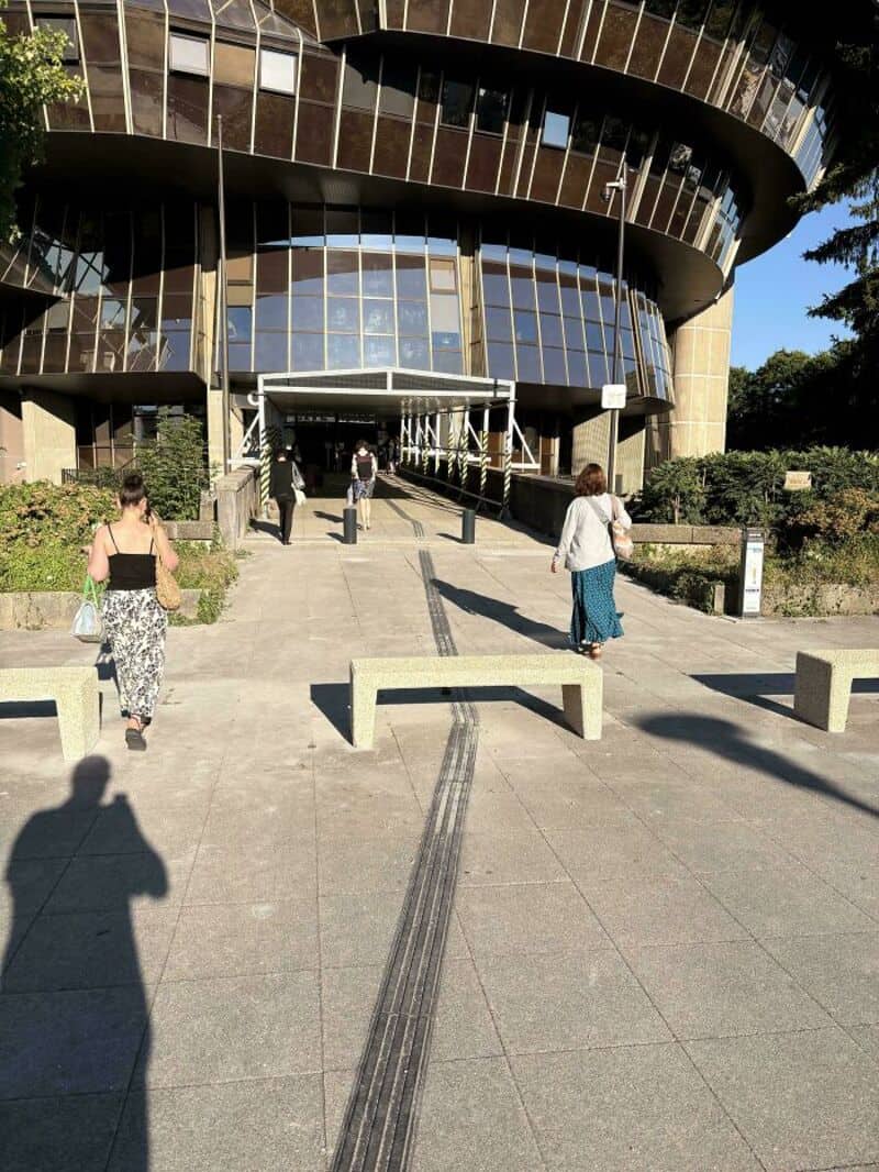 Building with a ramp that has tire tracks leading to the entrance.