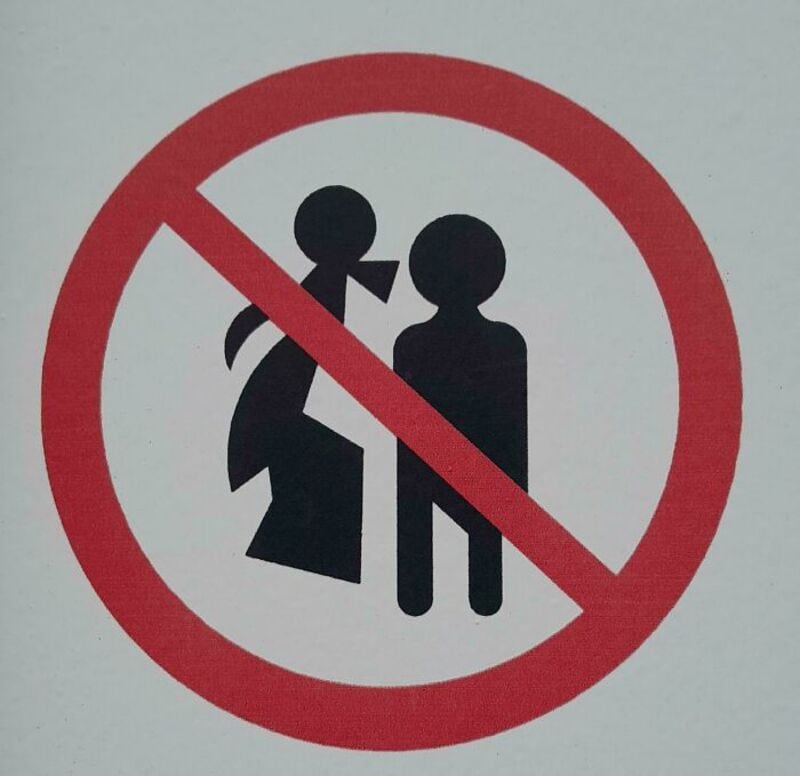 No kissing or physical contact allowed sign with a red circle and slash.