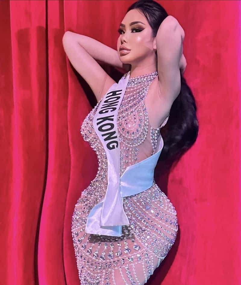 Miss Hong Kong contestant wearing a sparkling embellished gown with sash on a red curtain backdrop.
