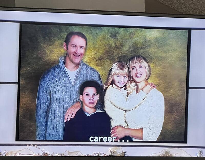 Two adults and two children smiling at camera.