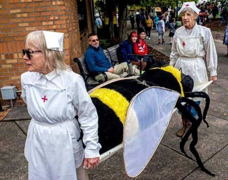 Nurse costumes with a bee-themed cart and a black dog in a costume.