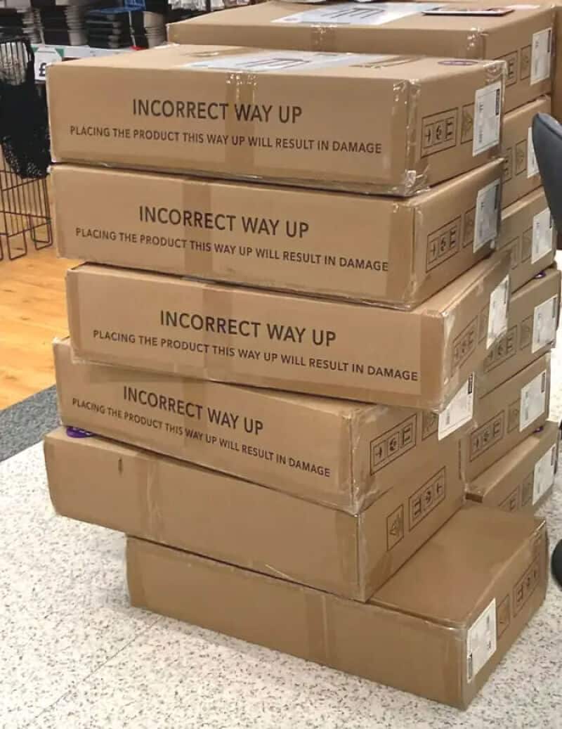 Stack of boxes with 'Incorrect Way Up' labels and warning about damage.