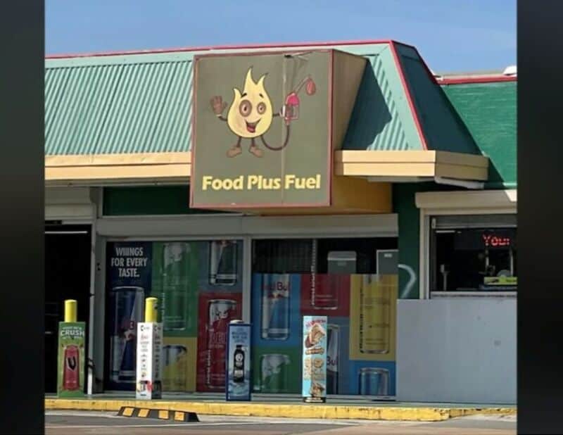 Food Plus Fuel sign with a cartoon flame character holding a drink and a cherry.