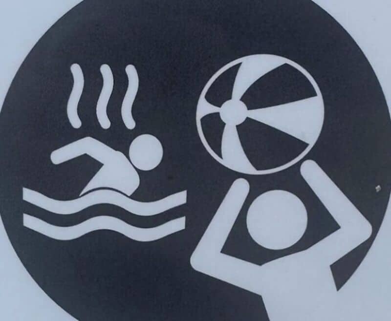 Pool warning sign with a swimmer, a fan, and a person in a wheelchair.