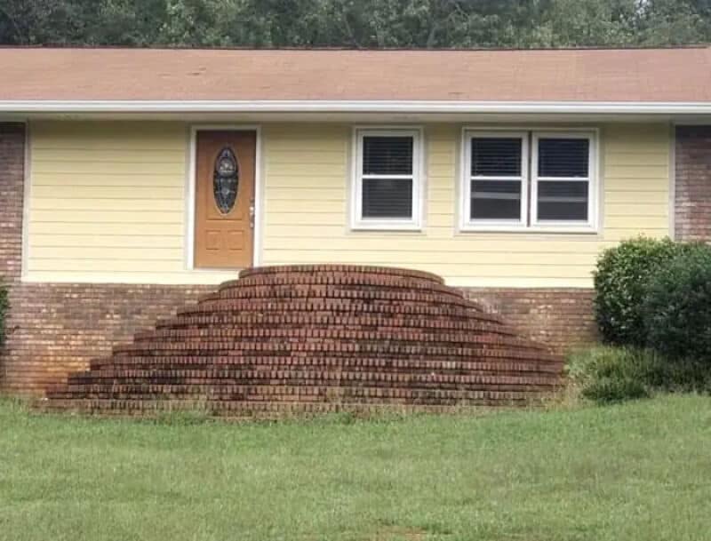 House with a brick staircase that looks like a pile of bricks in front of the door.