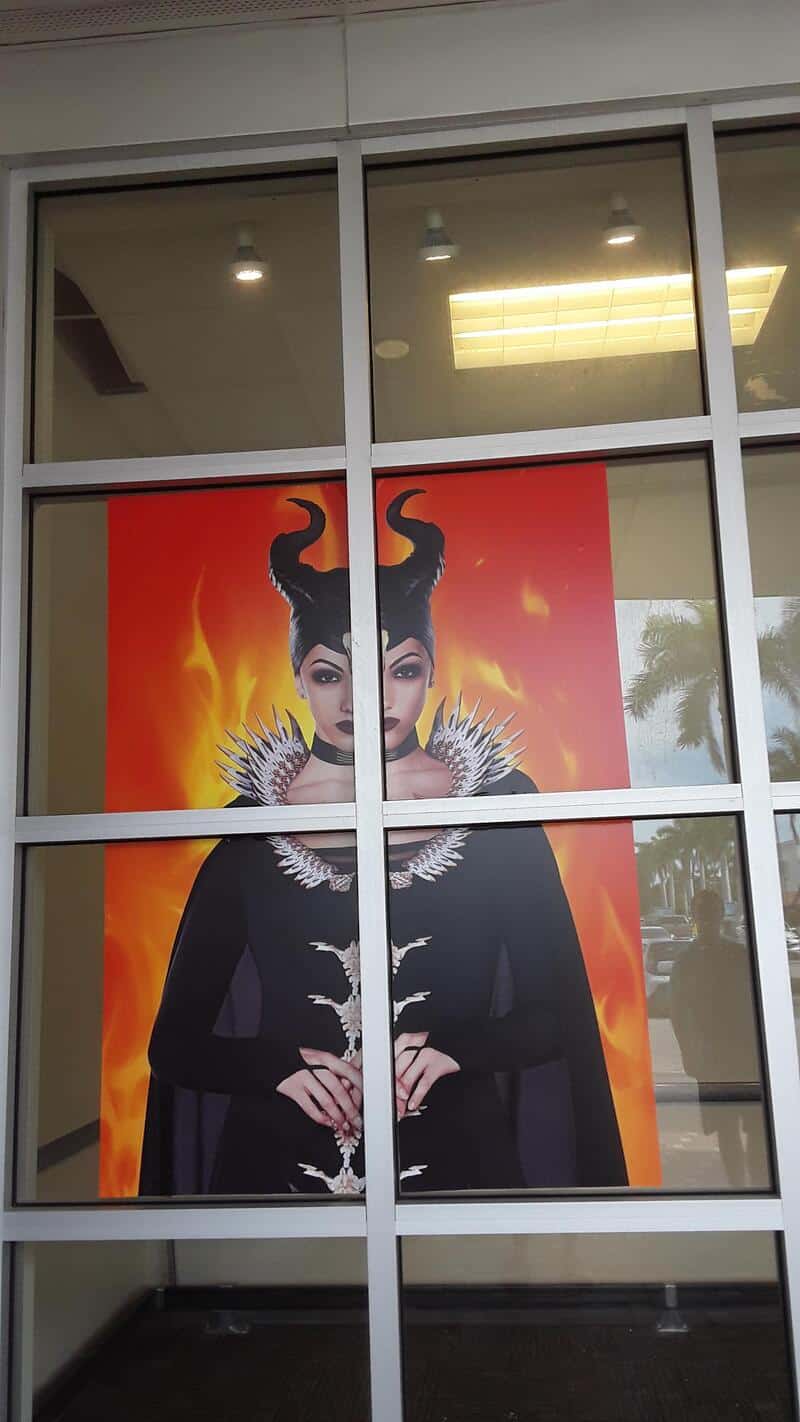 Halloween-themed figure with devilish horns, black attire, and a fiery background.