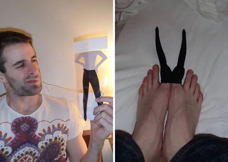 Person holding paper cutout of a bunny costume, with feet wearing bunny ears on bed.