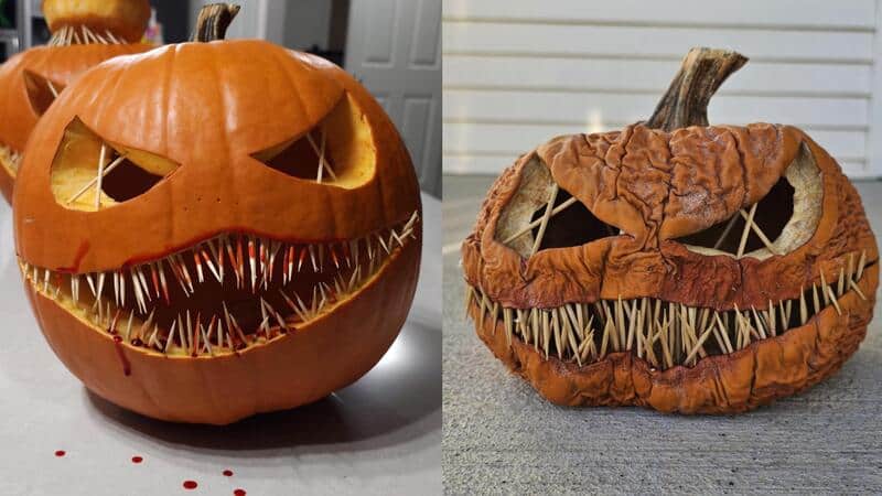 Two carved Halloween pumpkins with scary faces, one with sharp teeth and the other with a menacing g.