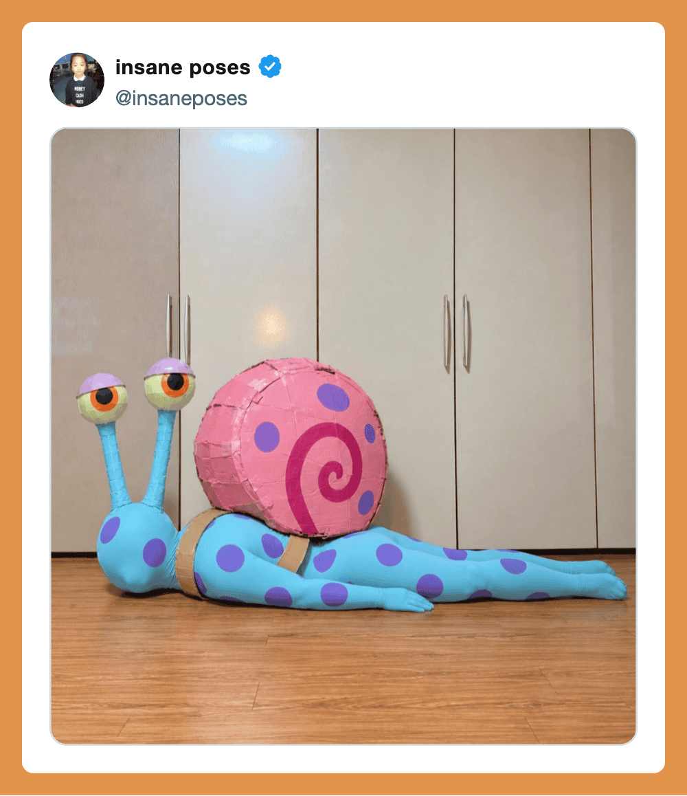 A blue cartoon snail costume with purple spots lying on the floor, large pink shell with spiral, in室.