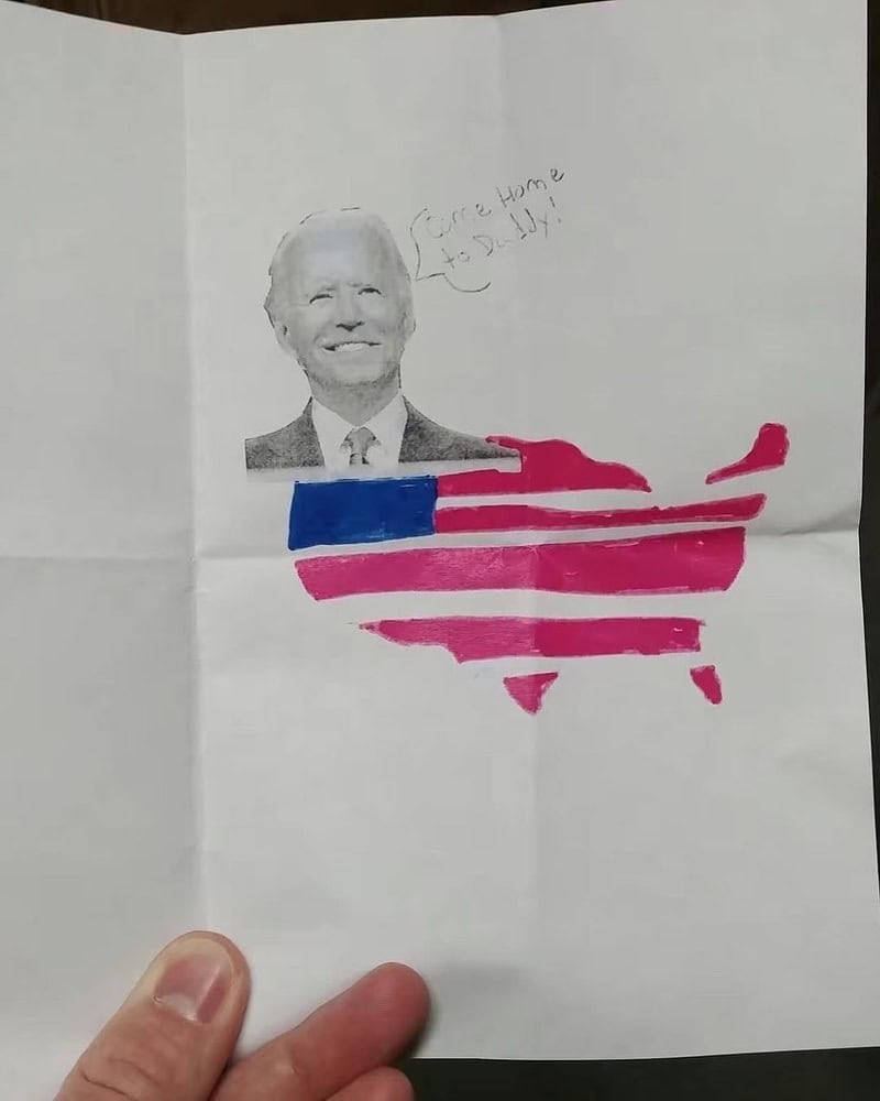 Joe Biden portrait with pink and blue map shape and handwritten note ‘Coming home’.