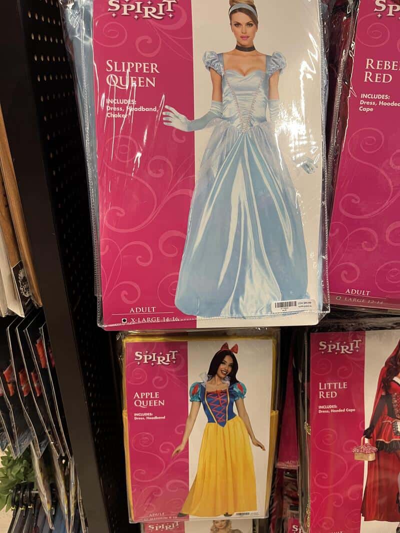 Costumes of a slipper queen and apple queen on store shelves.