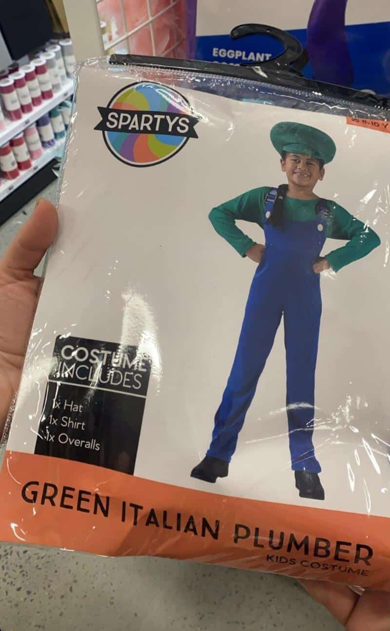 Child in green Italian plumber costume with hat and overalls, holding hands on hips.