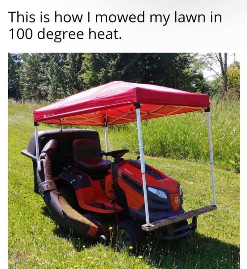 Lawn mower with a red canopy in a grassy yard, captioned about mowing in 100 degree heat.