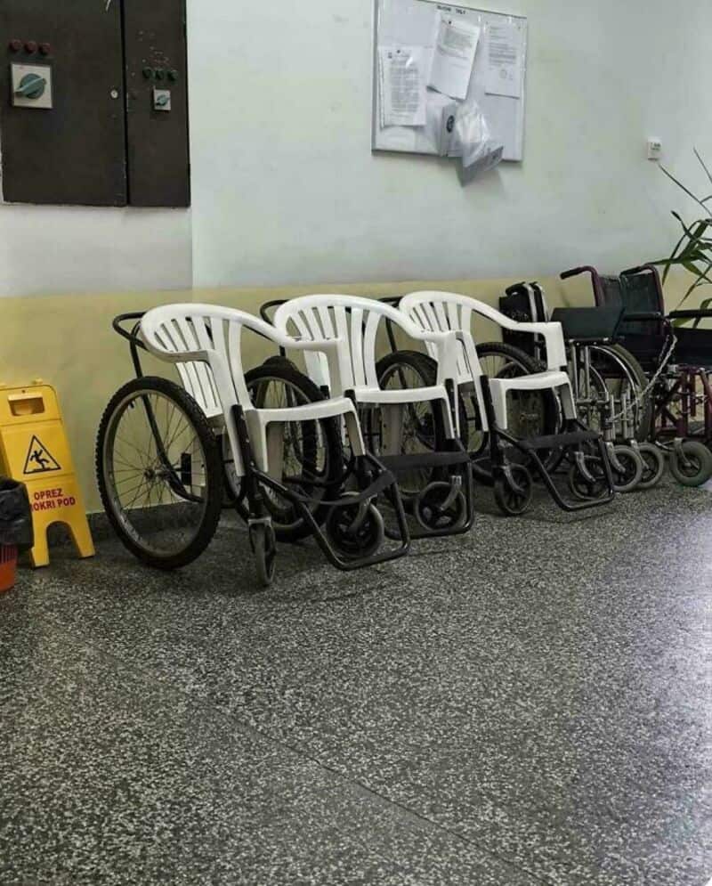 Chairs and wheelchairs lined up against a wall in a medical facility.
