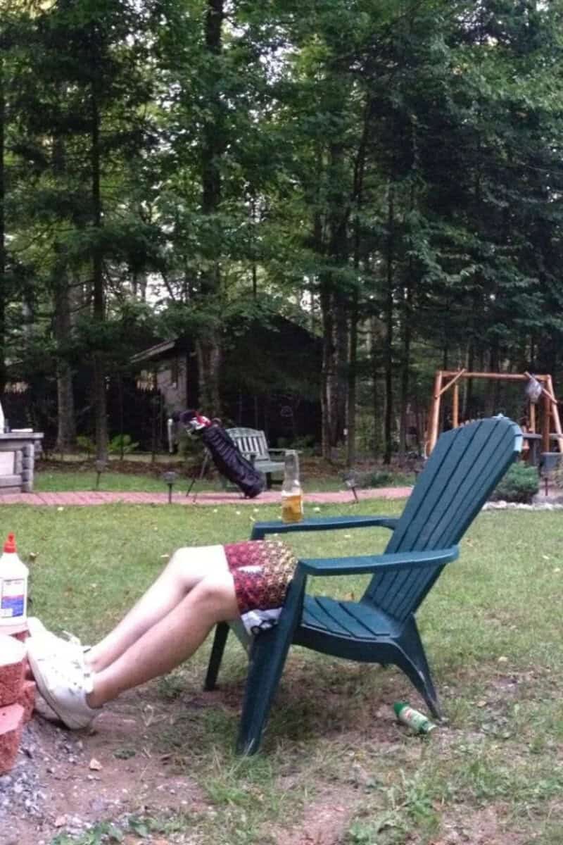 Person with legs in the air, head and upper body hidden behind a chair.