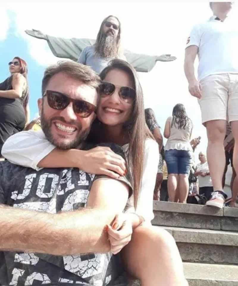 Couple taking a selfie with Christ the Redeemer in the background at Christ the Redeemer statue in a.
