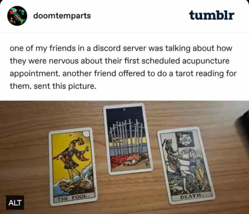 Three tarot cards: The Fool, The Hanged Man, and Death, on a wooden surface.