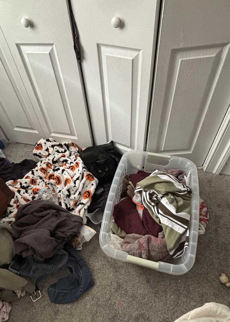 Clothes and laundry on the floor near a closet with a laundry basket.