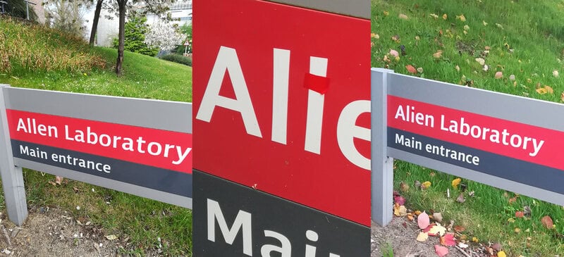 Signs for Allen Laboratory and Alien Laboratory with main entrance, some vandalism on the signs.