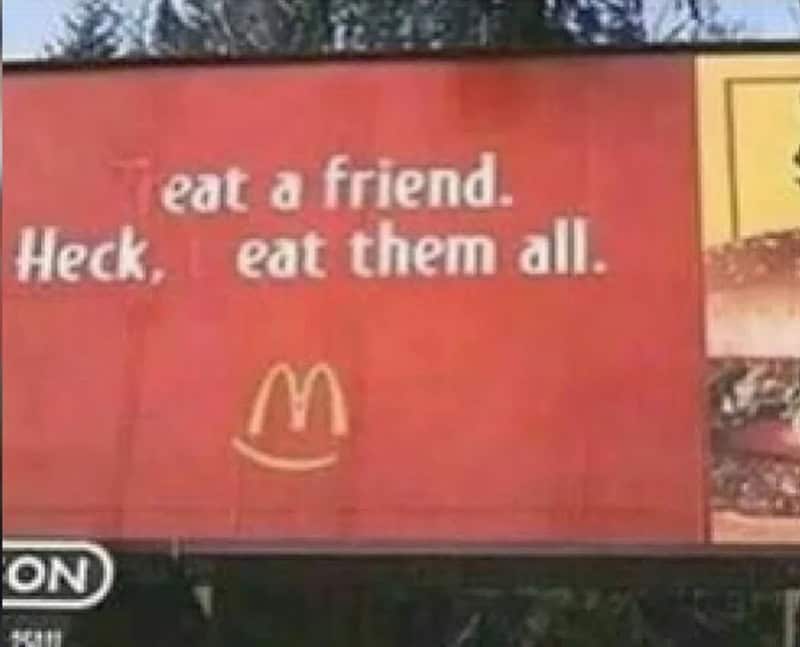 Sign with text 'eat a friend. Heck, eat them all.' and a McDonald's logo.