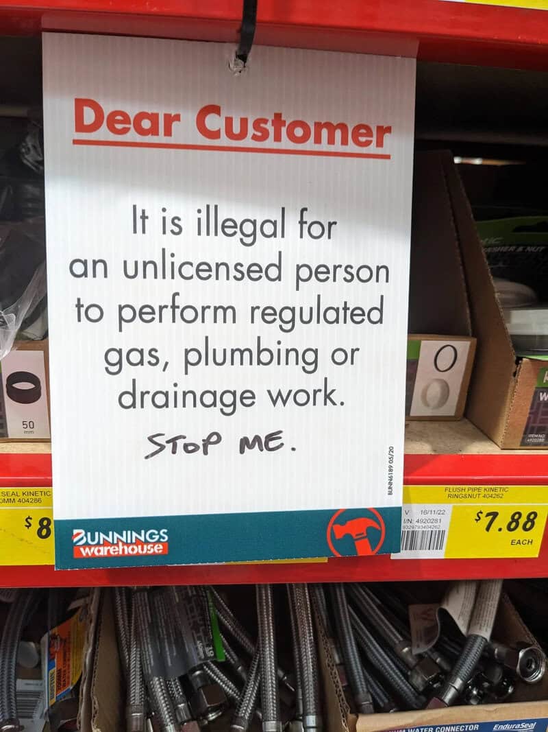 Warning sign about illegal work for unlicensed persons in plumbing and drainage.