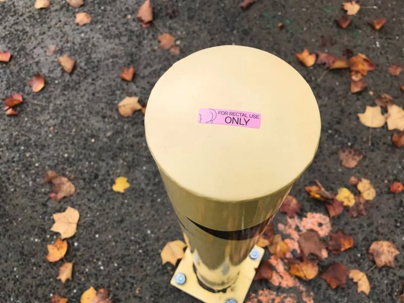 Yellow post with pink sticker that says 'FOR RECTAL USE ONLY' on top.