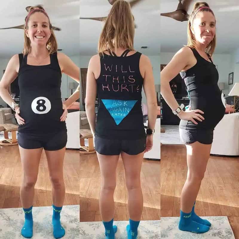Pregnant woman in a black tank top and shorts, showing her baby bump with humorous messages.