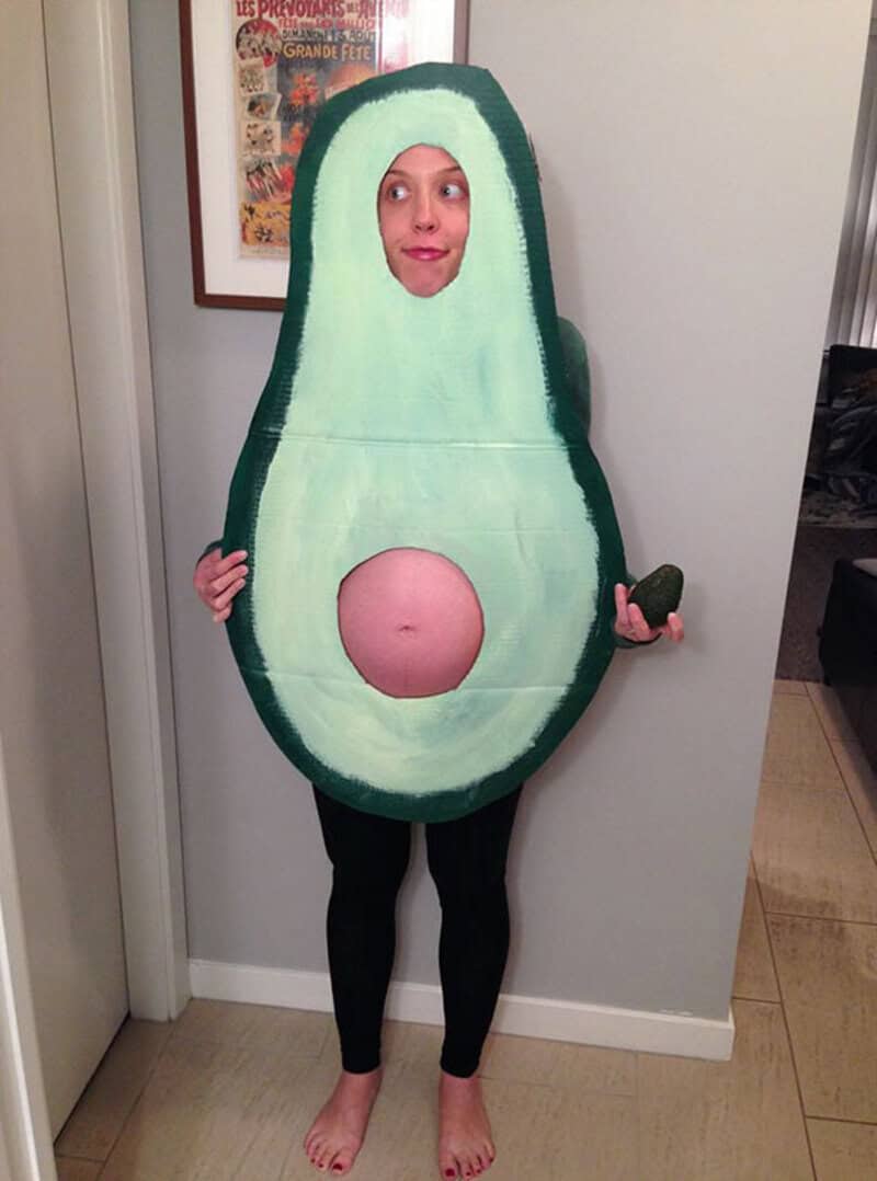 Person in avocado costume with face showing through the seed hole.