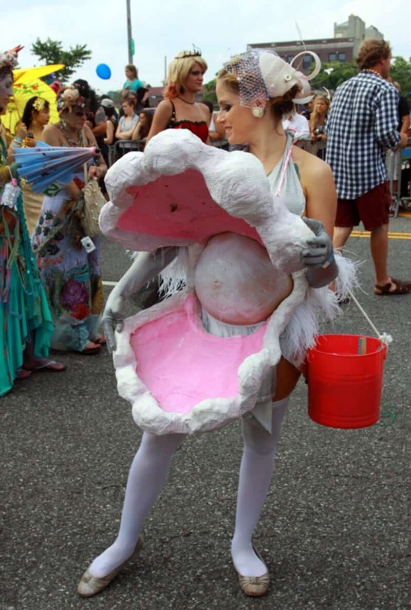 Pregnant woman in a giant open mouth costume at a parade.