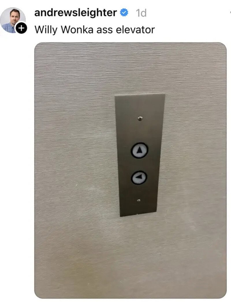 Elevator control panel with up and down buttons on a textured wall.