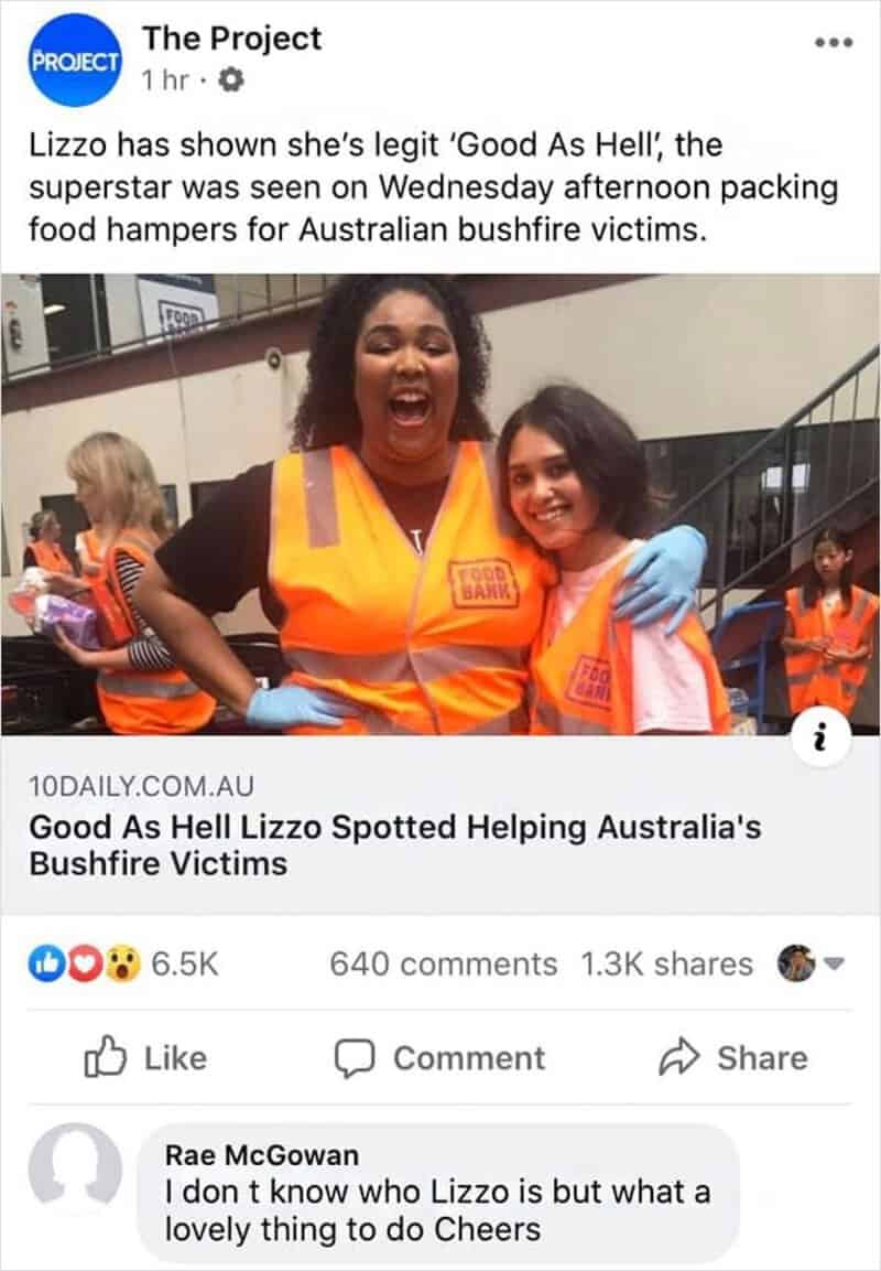 Lizzo in orange safety vest smiling with helper teammates inside a facility.