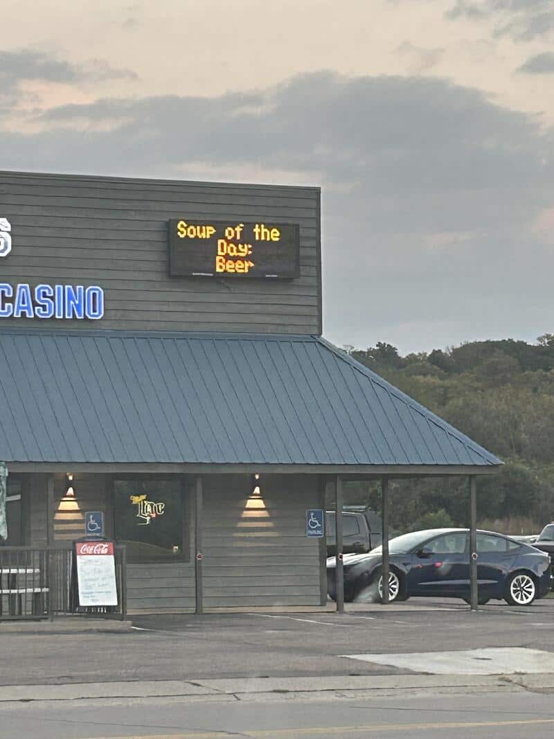 Sign on building reads 'Soup of the Day: Beer' with casino and parking lot in background.