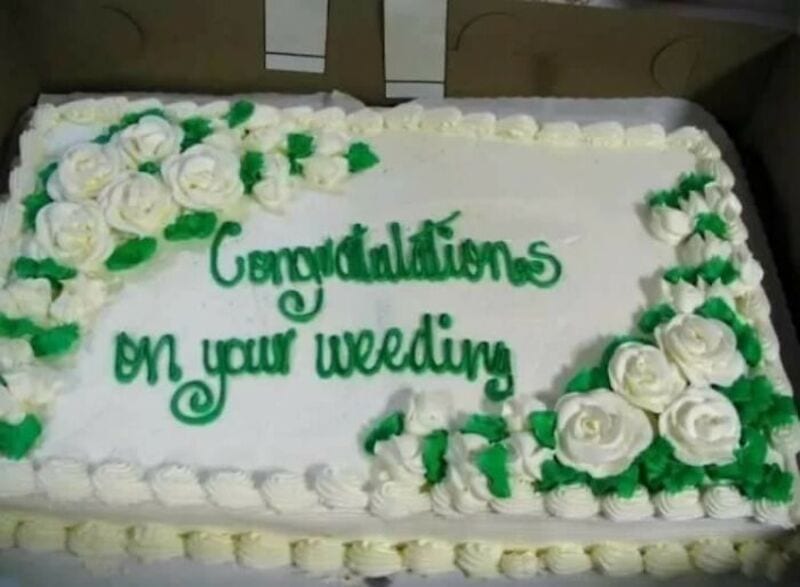 Hilarious cake with green text: 'Congratulations on your wedding' surrounded by white roses.