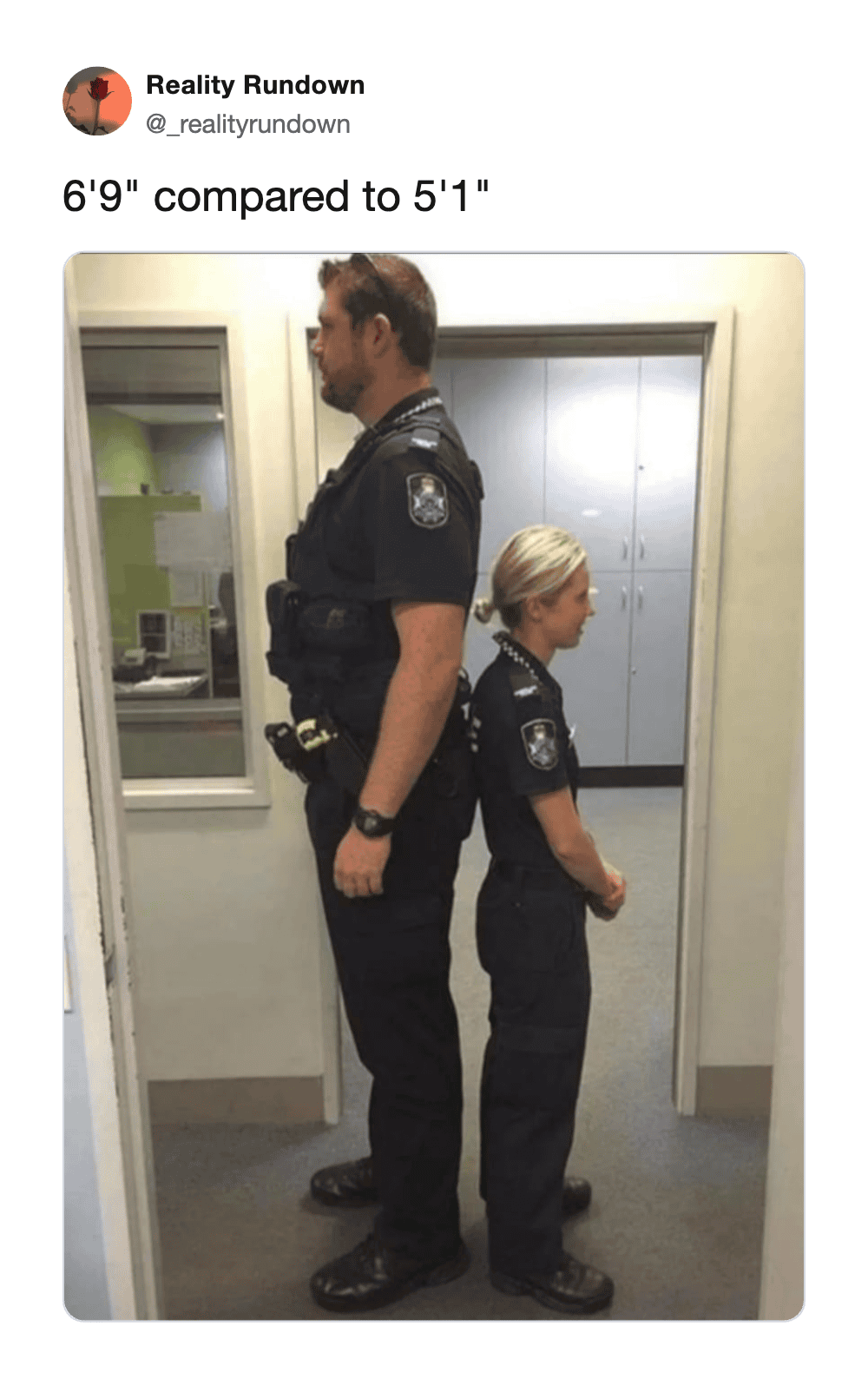 Comparison of a 6'9" man and a 5'1" woman in police uniforms standing back to back.