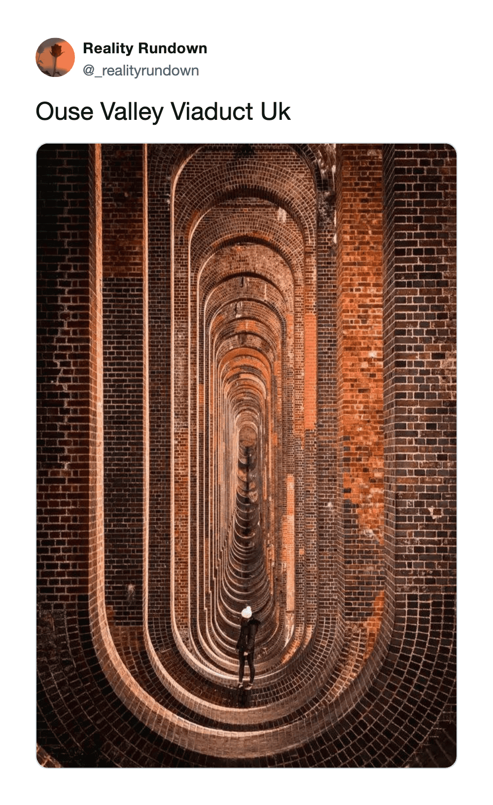 Ouse Valley Viaduct UK with brick arches and a person standing in the center.