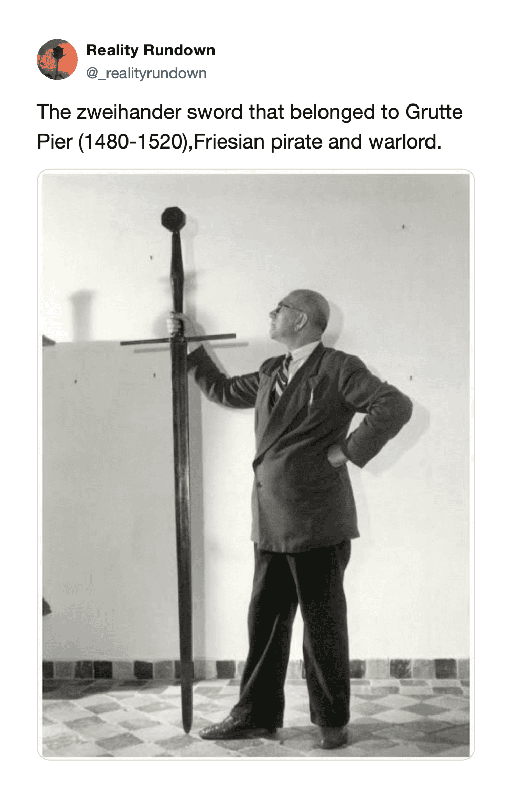 Man in suit with Zweihander sword at Grutte Pier museum.