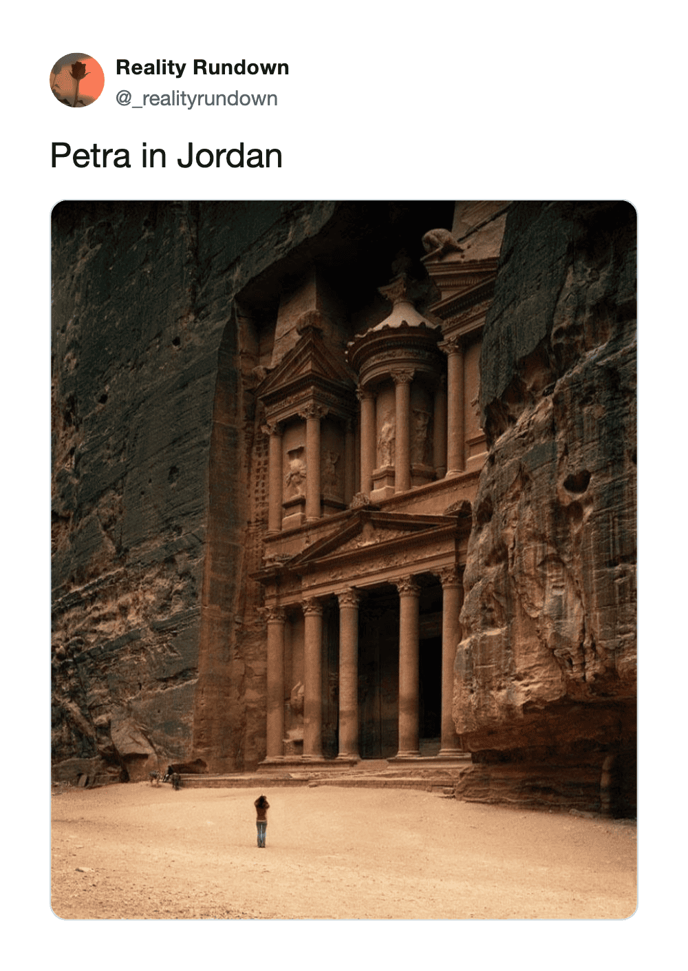 Petra in Jordan with a person standing in front of the ancient rock-cut architecture.