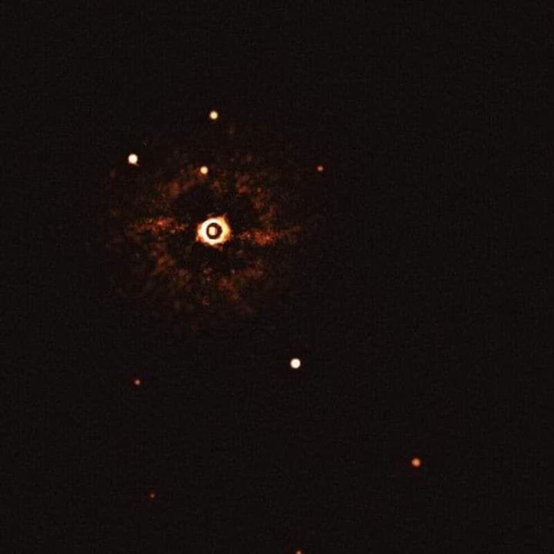 Bright explosion in space with debris and bright spots around a central fiery core.