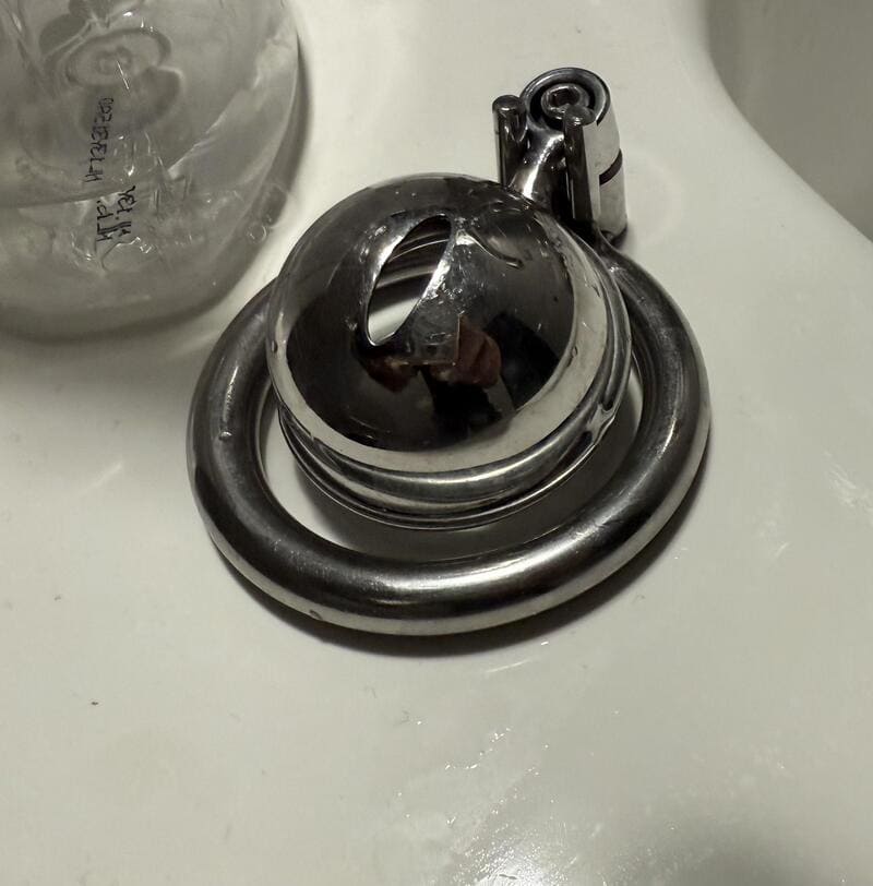 Close-up of a shiny, metallic, spiral-shaped object on a white surface.